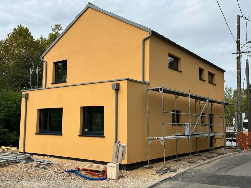 Construction d'une maison à enduit ocre en ossature bois par Bati M2G