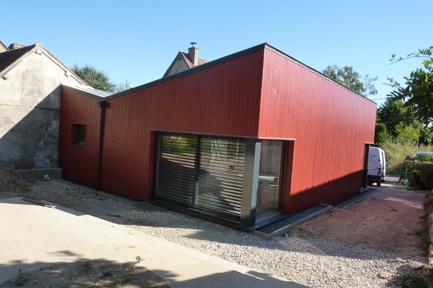 Extension à bardage métallique rouge réalisée par Bati M2G