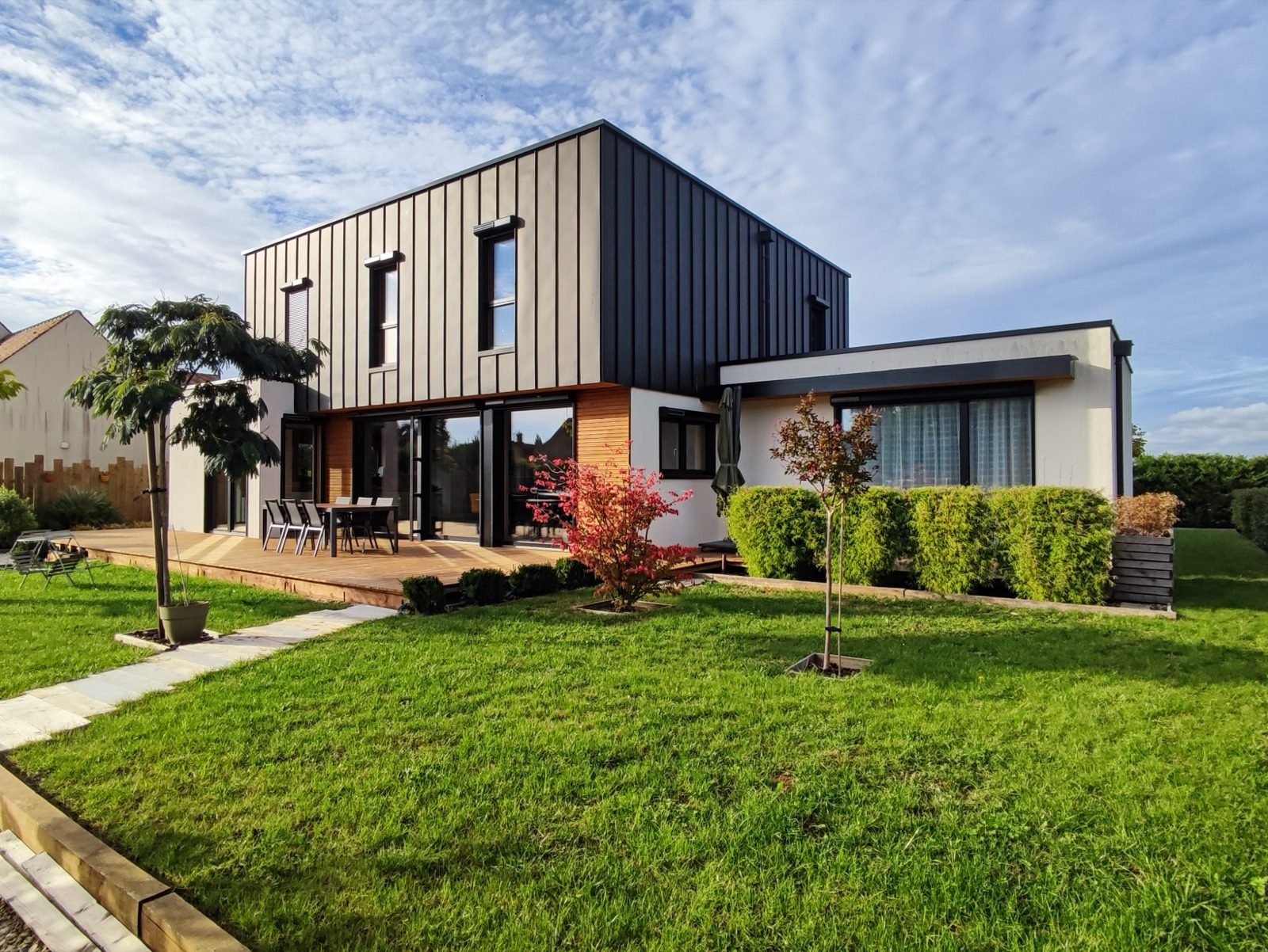 Maison moderne en ossature bois construite par Bati M2G, bardage bois et extension vitrée