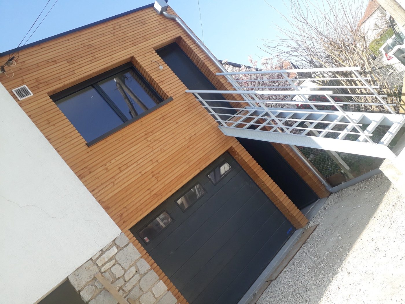 Garage et carport aménagés sous une maison, réalisation Bati M2G